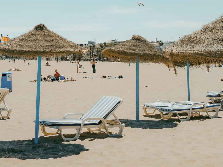 Strooien parasols en ligstoelen op het strand.