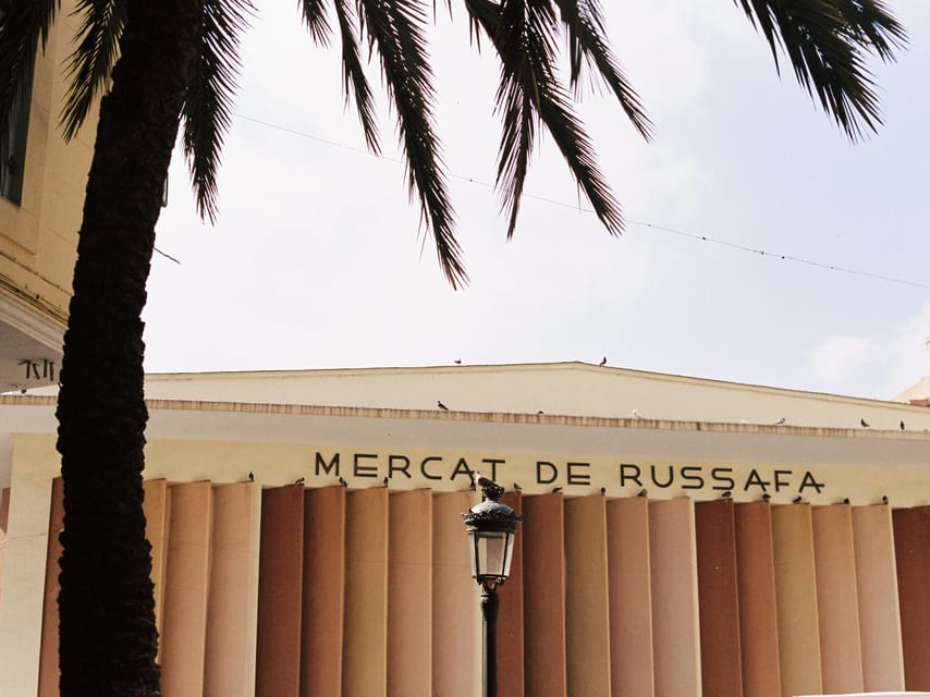 Gevel van de Mercado de Ruzafa onder een palmboom.